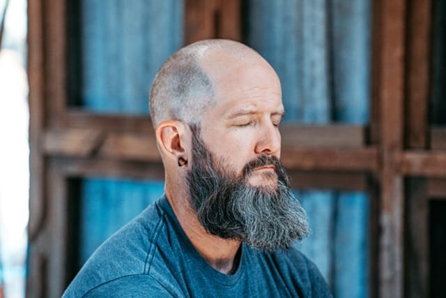A man sitting down practising nasal breathing.