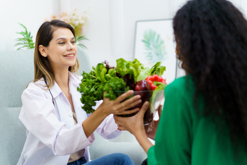 A holistic nutritionist holding a bowl with fruits and vegetables.