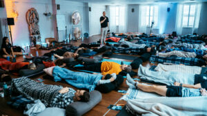 A group of people lying on the floor pracitising breathwork.