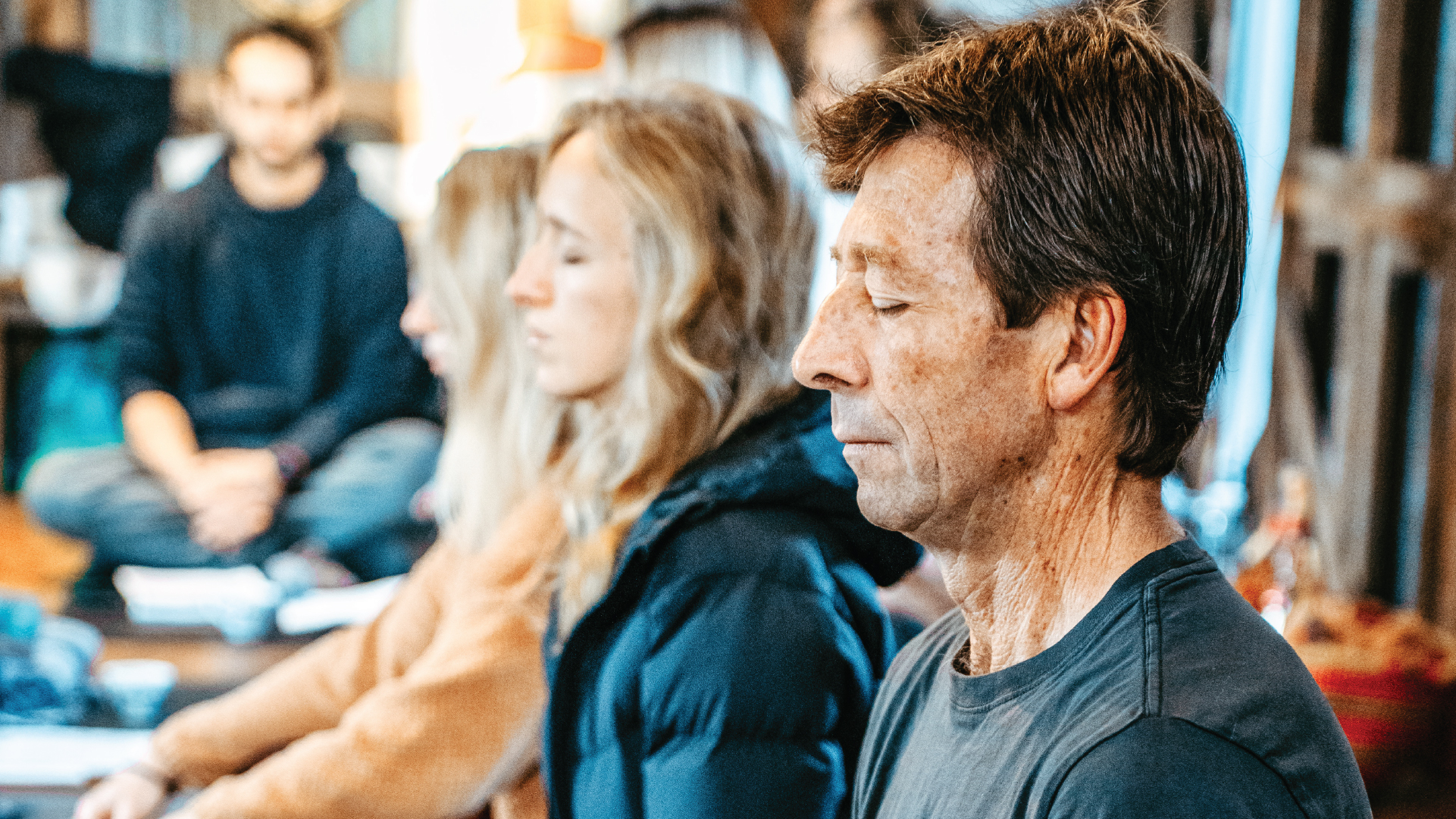 A group of people sitting on the floor practicing breathing retraining.