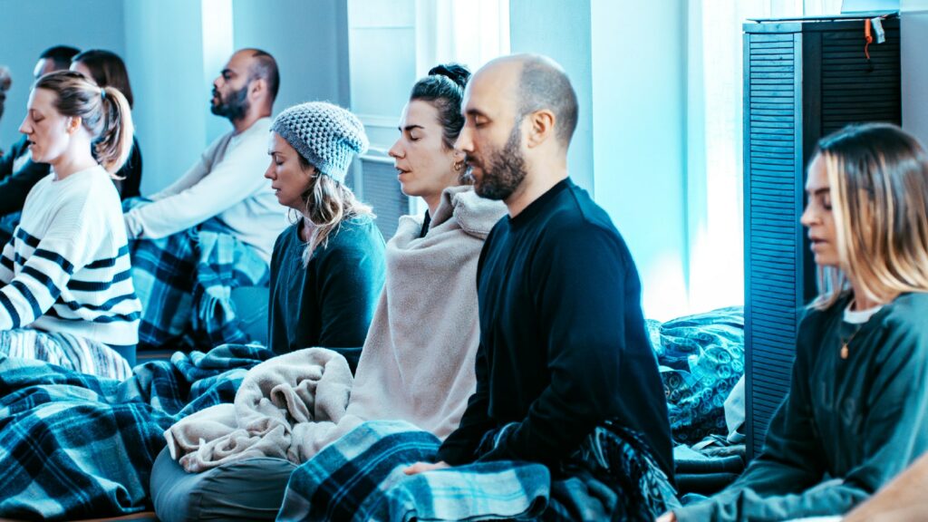 A group of people sitting practising deep breathing.